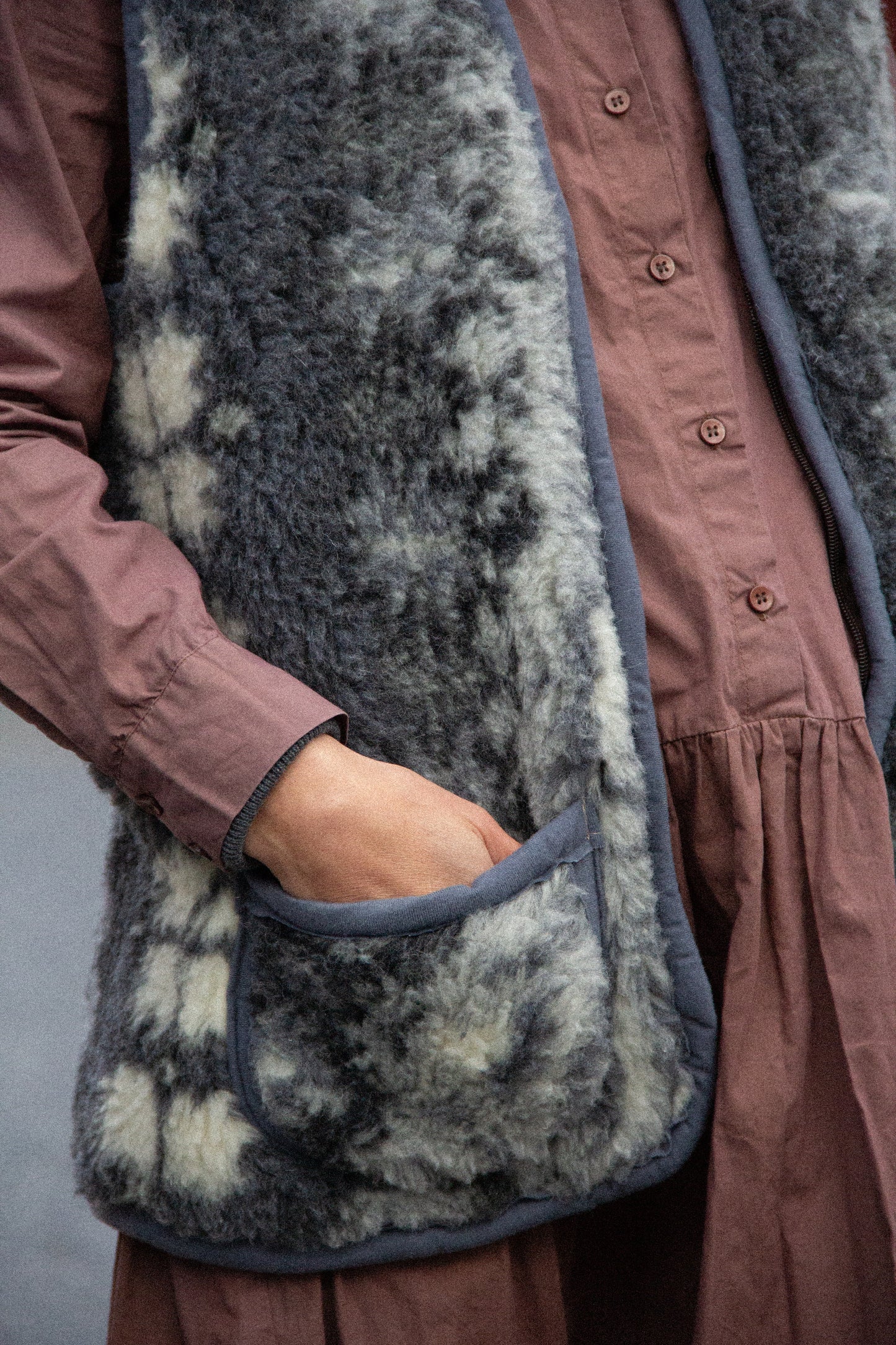 cosy warm and soft merino wool vest for man or woman in fluffy grey material with pattern featuring snow and reindeer - two cosy practical front pockets for storing phone or warming hands